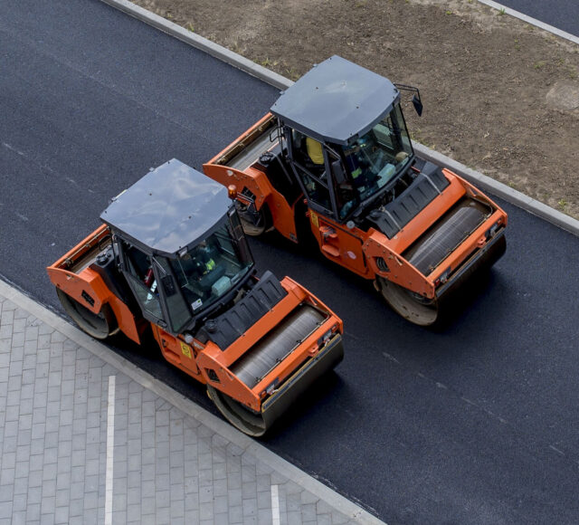 aerial-view-orange-vibratory-asphalt-roller-compactor-new-pavement (1) aerial-view-orange-vibratory-asphalt-roller-compactor-new-pavement (1)